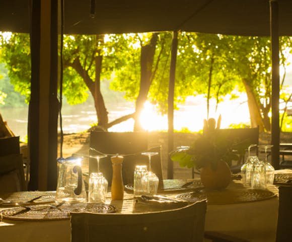 Dinner table set by shores of Omo river at Lales camp